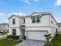 Front view of a charming two-story home with manicured landscaping and a paved driveway at 4361 Lana Ave, Davenport, FL 33897