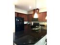 Stylish kitchen featuring dark granite countertops, wood cabinets, and modern appliances at 5105 Killarney Way, Kissimmee, FL 34746