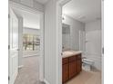 Well-lit bathroom with a vanity, toilet, and shower-tub combination, viewed from bedroom doorway at 517 Delta Ave, Groveland, FL 34736
