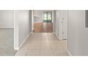 Hallway view featuring tile flooring that transitions into adjacent rooms with carpet and wood floors at 517 Delta Ave, Groveland, FL 34736