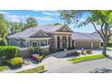 Elegant single-story house showcasing a manicured lawn and beautiful landscaping at 703 Cricklewood Ter, Lake Mary, FL 32746