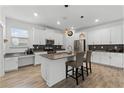 Modern kitchen with stainless steel appliances, white cabinetry, and a large island with seating at 11518 Rhyme Ave, Orlando, FL 32832