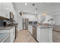 Open kitchen featuring an island, stainless steel appliances and a view of the living area at 11518 Rhyme Ave, Orlando, FL 32832