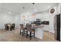 Bright open kitchen with modern appliances and an island with bar stool seating near the dining area at 11518 Rhyme Ave, Orlando, FL 32832