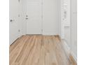 Bright hallway featuring a white door and attractive wood-look flooring at 13405 Sw 88Th Ter # 53, Ocala, FL 34473