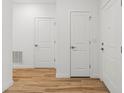 Bright hallway featuring white doors and attractive wood-look flooring at 13405 Sw 88Th Ter # 53, Ocala, FL 34473