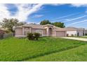 Attractive single-story home with well-kept lawn, two palm trees, and a two-car garage under a partially cloudy sky at 142 Barrington Dr, Kissimmee, FL 34758