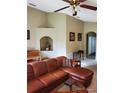 Inviting living room with a cozy brown leather sectional sofa and arched niche, creating a warm and welcoming space at 1457 Waukon Cir, Casselberry, FL 32707