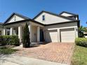 Charming home featuring a brick driveway, manicured landscaping and a two-car garage at 14675 Scott Key Dr, Winter Garden, FL 34787