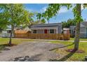 Quaint single-story home with red door, framed by a charming wooden picket fence at 1563 Immocalee St, Intercession City, FL 33848