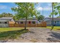 Quaint single-story home with a red door, framed by a charming wooden picket fence at 1563 Immocalee St, Intercession City, FL 33848