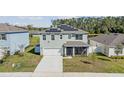 Well-maintained two-story home with solar panels and a two-car garage on a sunny day at 2736 Dumont Ln, Tavares, FL 32778