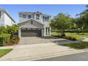 Charming two-story home with stone accents, a two-car garage, and a nicely paved driveway at 7641 Fairfax Dr, Kissimmee, FL 34747