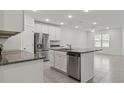 Open kitchen with stainless steel appliances, white cabinets and kitchen island at 8651 Sw 138Th St # 68, Ocala, FL 34473