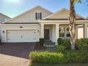 Charming single-Gathering home showcasing a well-manicured lawn, brick driveway, and covered entry at 10018 Halesia Woods Dr, Orlando, FL 32832