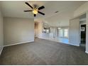 Open living space with ceiling fan flows into the kitchen with tile flooring and breakfast bar at 110 Evergreen Dr, Auburndale, FL 33823