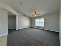 Spacious carpeted living room with a ceiling fan and large window offering natural light at 110 Evergreen Dr, Auburndale, FL 33823