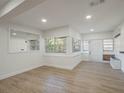 Open concept living area featuring wood-look floors and a large window view at 1208 Bonaire Dr, Leesburg, FL 34748