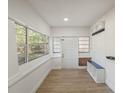 Bright and airy sun room with large windows, bench seating, and tile floors at 1208 Bonaire Dr, Leesburg, FL 34748