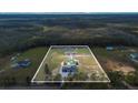 Expansive acreage showcasing a modern home, pool, and outbuildings surrounded by lush greenery at 12323 Sweet Hill Rd, Polk City, FL 33868