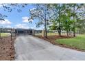 Gated entrance leading to a modern home with a long driveway and lush landscaping at 12323 Sweet Hill Rd, Polk City, FL 33868