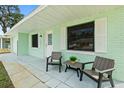 Inviting porch with seating offers a relaxing outdoor space, black shutters, and painted brick at 124 Oakridge Ave, Edgewater, FL 32132