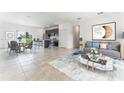 The open-concept living space features tile floors, modern furnishings, and a view of the kitchen at 13687 Sw 33Rd Cir, Ocala, FL 34473