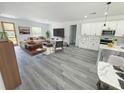 Spacious open-concept living and kitchen area with modern décor and beautiful wood-look floors at 16947 Sw 22Nd Terrace Rd, Ocala, FL 34473