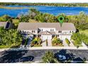 Aerial view of townhomes near lake, featuring lush landscaping and convenient parking at 1968 Compass Flower Way, Ocoee, FL 34761