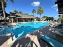 Community pool with plenty of lounge chairs and palm trees for relaxation and enjoyment at 1968 Compass Flower Way, Ocoee, FL 34761
