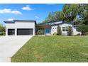 Charming one-story home offers a contemporary design, lush lawn, and a striking blue front door at 2058 Washington Ave, Sanford, FL 32771