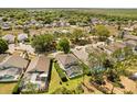 Aerial view of a residential neighborhood with mature trees, backyard pools, and well-maintained landscaping at 229 Troon Cir, Davenport, FL 33897