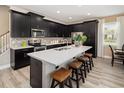 Modern kitchen with black cabinetry, stainless steel appliances, and a large island with quartz countertops at 2327 Distant Sun Trl, Kissimmee, FL 34747
