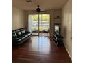 Living room with ceiling fan, hardwood flooring, access to screened porch and built in shelves at 2717 Maitland Crossing Way # 4-103, Orlando, FL 32810