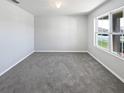 Empty bedroom features neutral carpet, white walls, and a large window providing natural light at 3056 Sangria St, Kissimmee, FL 34744