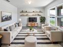 Bright living room featuring a plush rug, comfortable seating, and stylish shelving over the entertainment center at 3056 Sangria St, Kissimmee, FL 34744
