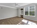 Bright, airy bedroom with hardwood floors, built-in desk, a ceiling fan, and a large window at 3398 Greenwich Village Blvd # 104, Orlando, FL 32835