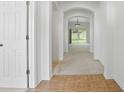 Bright hallway with neutral tones, archways, ceramic tile at the door, and view to backyard at 3747 Moon Dancer Pl, St Cloud, FL 34772