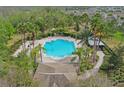 Aerial view of a sparkling community pool surrounded by lush landscaping and ample seating at 3747 Moon Dancer Pl, St Cloud, FL 34772