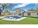 This backyard features a sparkling pool and spa, surrounded by lush greenery and a patio area at 409 W 2Nd Ave, Windermere, FL 34786