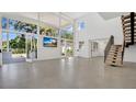 Bright, spacious living room with tall windows, tile floors, and open staircase at 409 W 2Nd Ave, Windermere, FL 34786