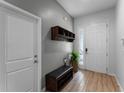 Welcoming foyer with light wood-look floors, storage bench, and coat rack at 418 Marcello Blvd, Kissimmee, FL 34746