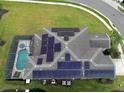 Aerial view of a roof with solar panels, a pool, pool enclosure, and lawn at 6049 Broad Oak Dr, Davenport, FL 33837