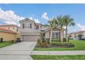 Inviting two-story home with well-manicured lawn, showcasing tropical landscaping and a neutral color scheme at 6049 Broad Oak Dr, Davenport, FL 33837