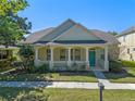 Charming single-story home with a covered front porch, columns, and manicured lawn at 6610 Helston Ln, Windermere, FL 34786