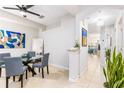 Dining area with a glass table, blue chairs, and a view into the entry hall with tile floors at 698 Seabrook Ct # 103, Altamonte Springs, FL 32714