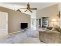 Open living area with neutral walls, vaulted ceiling with fan, and sliding glass door access at 704 Sky Tree Ct, New Smyrna Beach, FL 32168