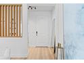 Bright foyer with light wood floors, white walls, modern wooden slat accent, and ample natural light at 8010 Soldierwood St, Winter Garden, FL 34787