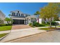 Charming two-story home with a brick driveway, two-car garage, and well-manicured landscaping under a clear blue sky at 8010 Soldierwood St, Winter Garden, FL 34787