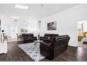 Open floor plan with a cozy living room featuring dark wood floors and comfortable seating at 8073 Santee Dr, Kissimmee, FL 34747